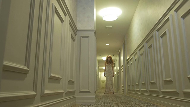 穿着婚纱的女孩在走廊里摆姿势视频下载