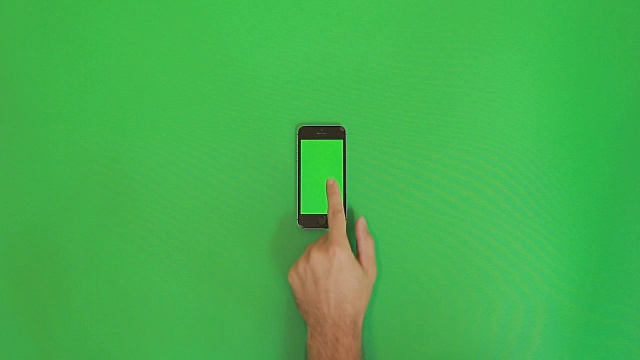 智能手机在绿色屏幕上向下滑动手势。垂直视频素材