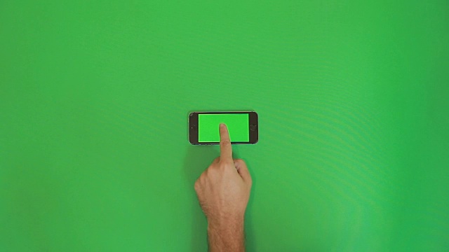 智能手机在绿色屏幕上点击手势。水平视频素材