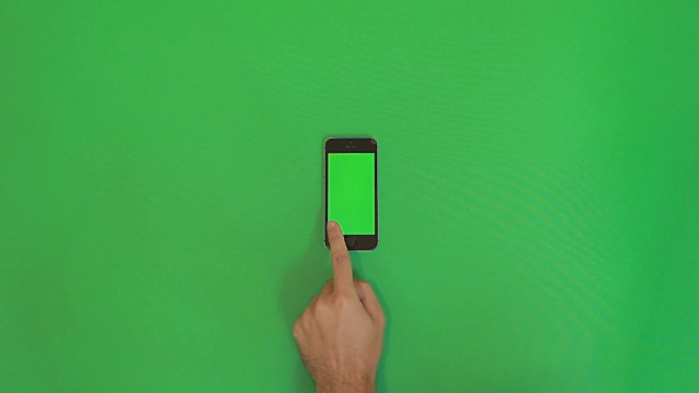 智能手机在绿色屏幕上滑动右手手势。垂直视频素材