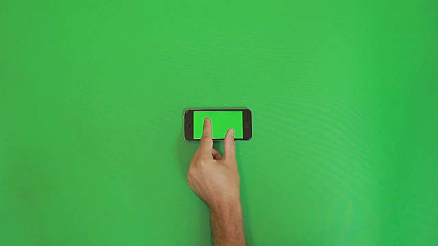 智能手机在绿色屏幕上缩小手势。水平视频素材