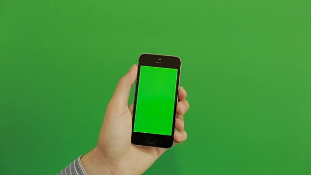 智能手机在绿色屏幕上点击手势。垂直视频素材