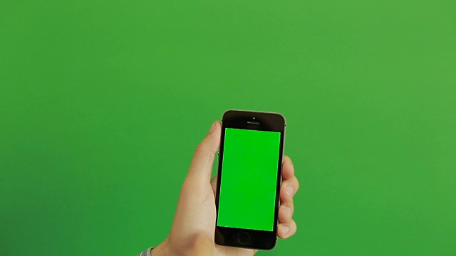 智能手机在绿色屏幕上滑动手势。垂直视频素材