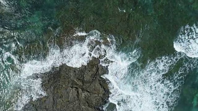 空中的慢动作镜头海浪冲向岩石海岸视频素材