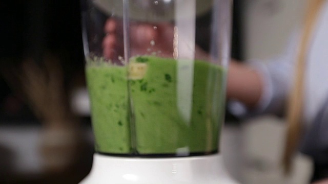 一名女子正在调配原料制作绿色奶昔视频素材