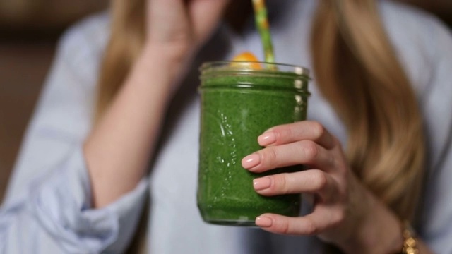 喝绿色排毒蔬菜奶昔的女人视频素材