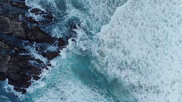 空中缩放在岩石海岸的海浪打破的镜头视频素材