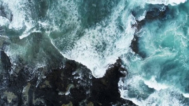 空中的慢动作镜头海浪冲向岩石海岸视频素材