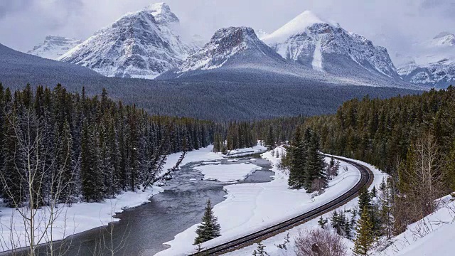 火车轨道的时间流逝旁边的河流在下雪的山区视频素材