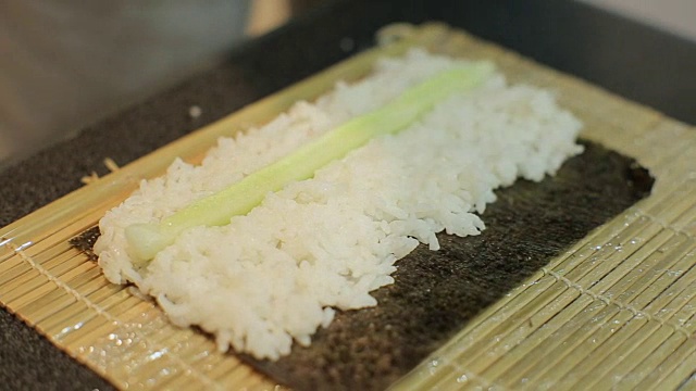 手做长寿司卷。米饭配鱼片。寿司师傅展示厨艺。著名的日本菜。视频素材