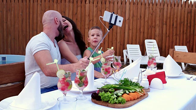 家庭照片让手机贴着自拍照，欢快的家长和孩子聚会，户外晚餐在亲戚圈里的人，幸福的家庭视频下载