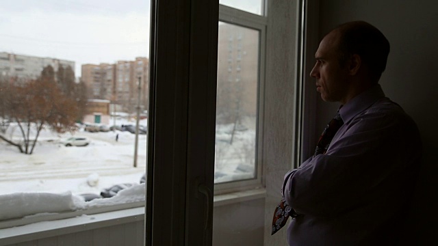 一个男人站在窗边视频下载