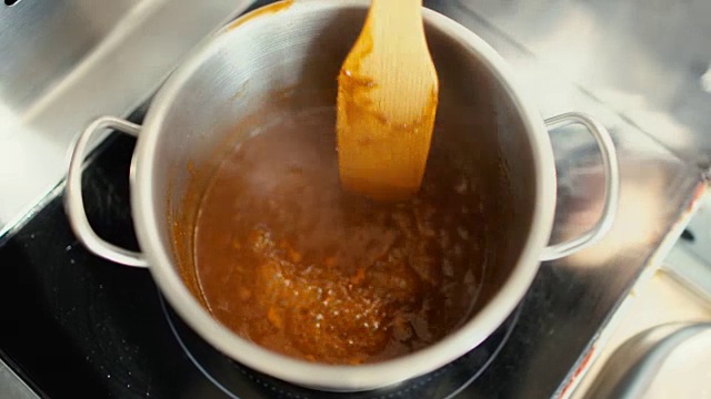 特写的专业厨师准备肉汁酱与香料在餐厅厨房的烤箱视频素材