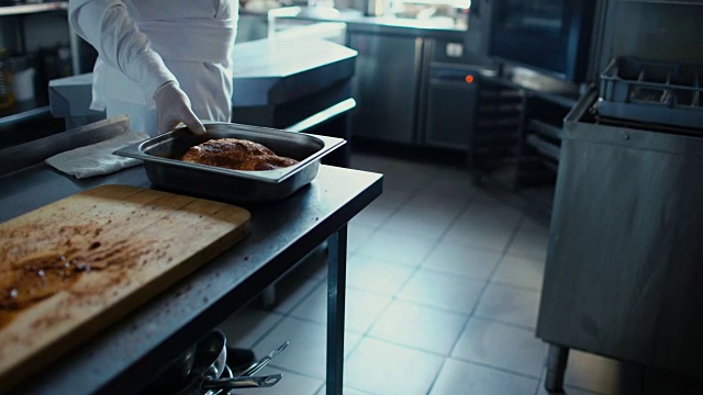专业厨师将菜肴放入餐厅厨房的烤箱中视频素材