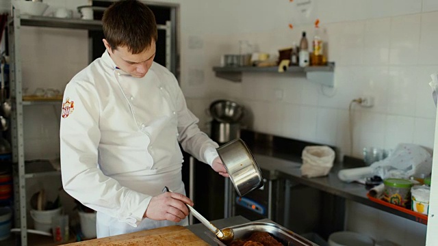 专业厨师在餐厅厨房用肉汁调味排骨视频素材