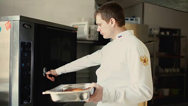 专业厨师将菜肴放入餐厅厨房的烤箱中视频素材