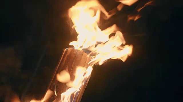 一个男人的手，用火把点燃木头。火关闭视频素材