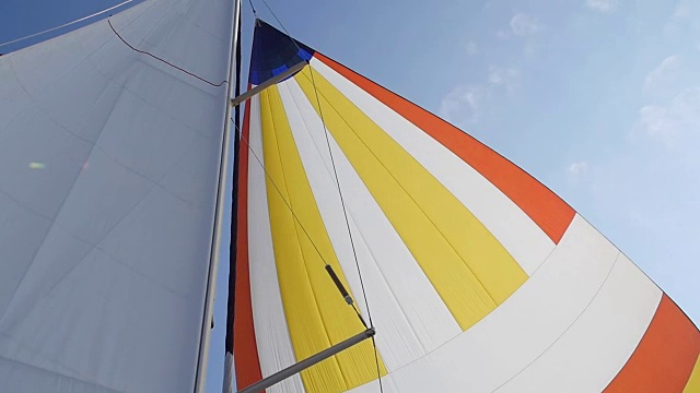 风在天空的背景上吹着五颜六色的帆。视频素材