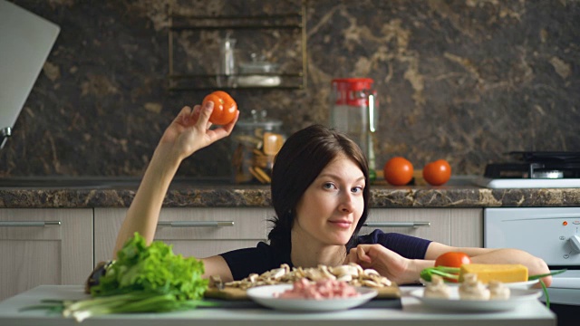 美丽微笑的女人做饭玩蔬菜在桌子上在家里厨房视频下载