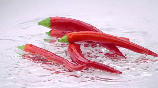 苦涩的红辣椒落在桌上。视频素材