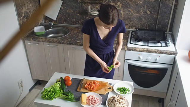 俯视图美丽的女人做饭切蔬菜在厨房在家里视频素材