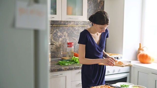 早餐纸上模糊背景的女人在厨房里做饭视频素材