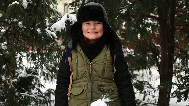冬天的孩子男孩与雪玩的肖像视频下载
