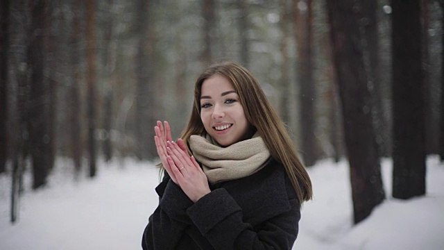 阳光明媚的户外冬季肖像20岁年轻迷人的女人。美丽的女孩微笑在冬天的森林视频素材
