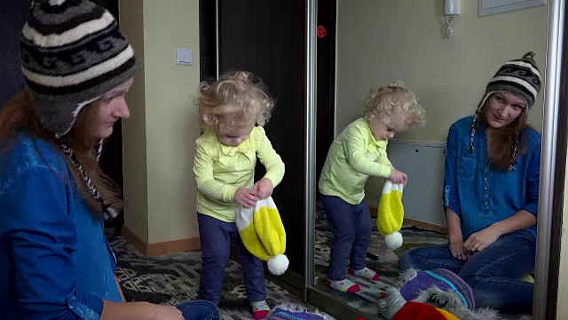 好玩的家庭女孩测量温暖的冬天帽子近镜视频素材