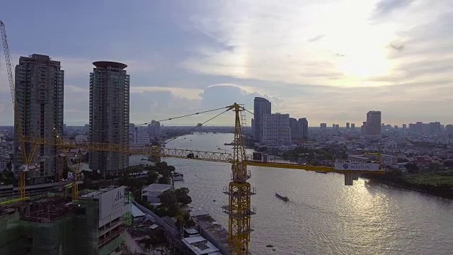 Chaopraya河附近的建筑工地和城市背景的起重机视频素材