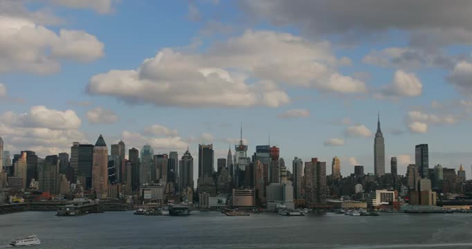 时间流逝广域网拍摄的云在曼哈顿中城天际线在下午与船在哈德逊河在前景视频素材