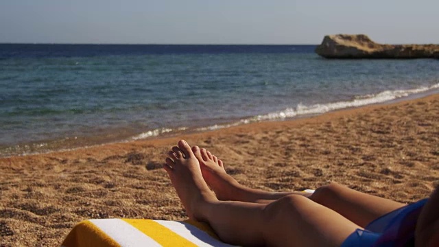 女人的腿躺在沙滩太阳躺椅靠近红海，埃及视频素材