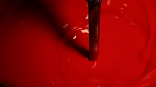 红漆在大桶里搅拌。视频下载