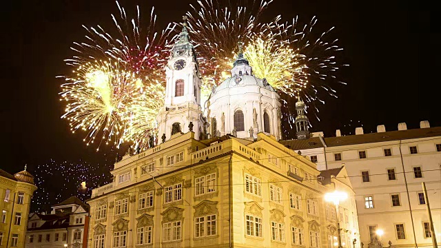 在马拉斯特拉纳或较小的一边的尼古拉斯教堂和假日烟花，布拉格美丽的老部分，捷克共和国(夜景)视频素材