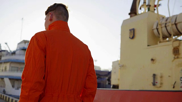身穿橙色制服的码头工人在港口行走，控制港口的工作流程视频素材