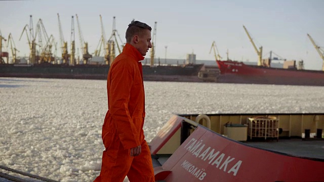 身穿橙色制服的码头工人在港口行走，控制港口的工作流程。冰的海洋视频素材