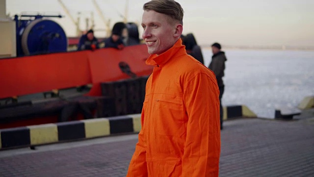 身穿橙色制服的码头工人在港口行走，控制港口的工作流程。视频素材