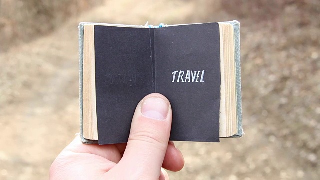 旅行，旅行者拿着一本有文字的书视频下载