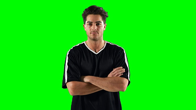 一个自信的足球运动员站在绿幕前视频素材
