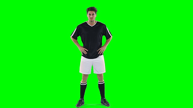 一个自信的足球运动员站在绿幕前视频素材