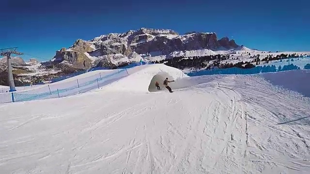 愉快的冬季极限公园滑雪。在阿尔卑斯山的一个度假胜地，一群滑雪者开车穿过一条雪隧道视频素材