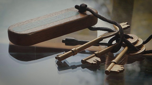 金属钥匙，木制钥匙圈拉集中在玻璃桌上视频下载