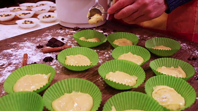 女人的手把做松饼的生面团放在纸烤盘里视频素材