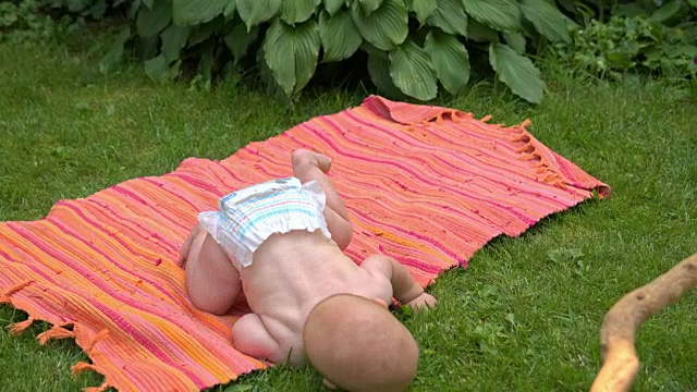 婴儿在草地上的地毯上玩视频下载