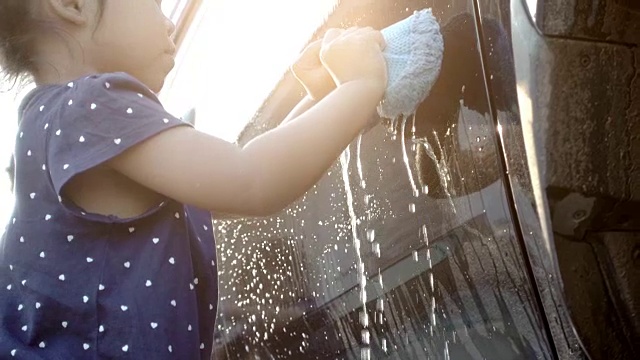 亚洲小女孩和家人一起洗车，慢镜头拍摄视频素材