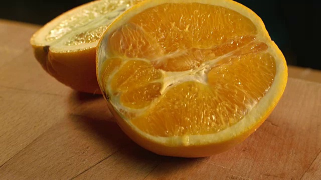 新鲜的橘子水果一半。美味的橘子切片在木制的背景视频素材