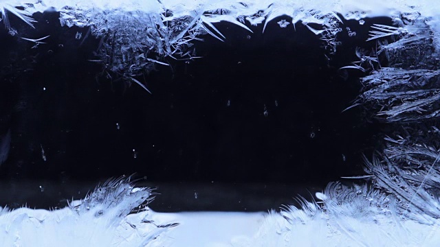 冰冻的图案从左到右覆盖着黑暗的背景视频素材