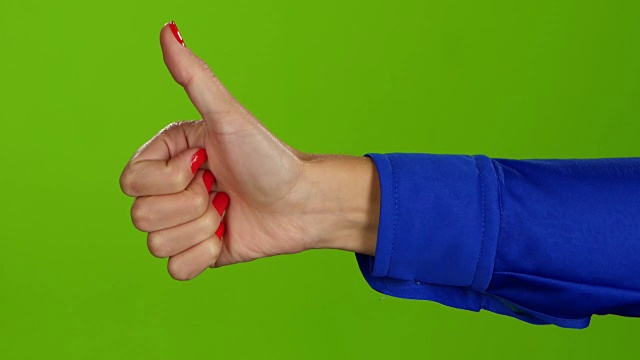 在绿色屏幕背景上竖起大拇指的手。手语视频下载
