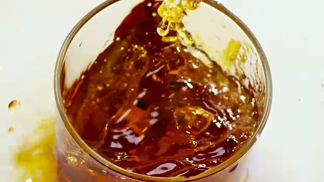 两块冰块掉进了装有威士忌的玻璃杯里。俯视图视频素材