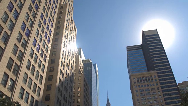 特写:夏日的阳光反射在高大的现代玻璃办公大楼的窗户上视频下载